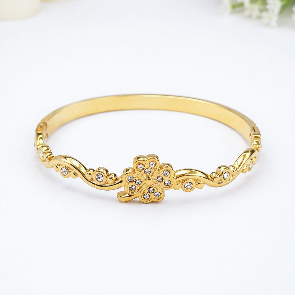 Gold-plated bangle bracelet featuring a central flower design with sparkling crystals