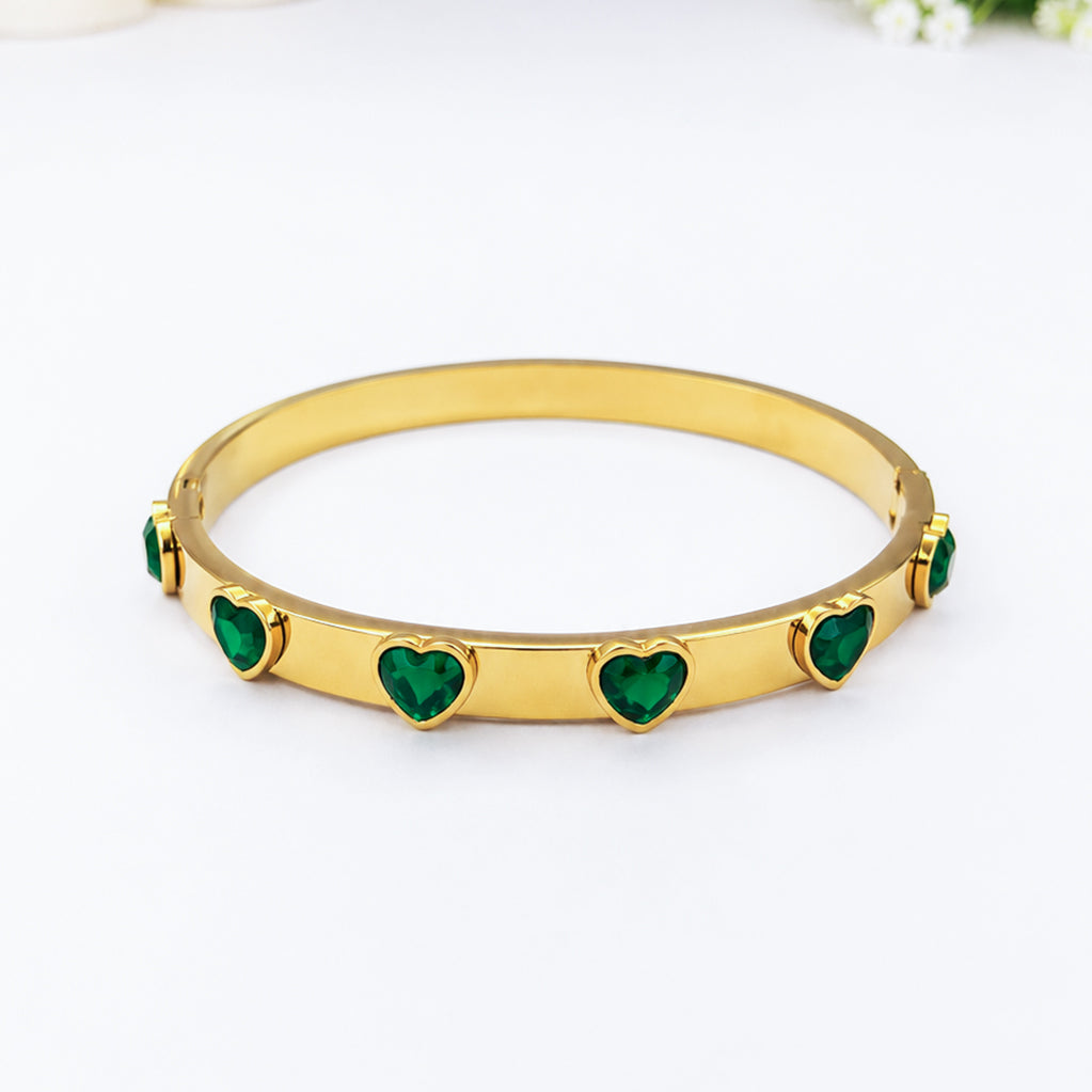 Gold-plated bangle bracelet with inlaid green heart-shaped crystals