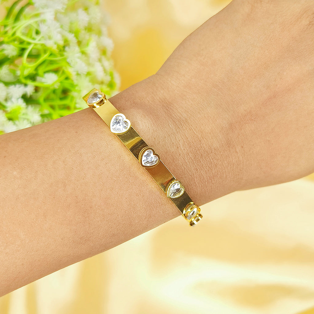 Gold-plated bracelet with heart-shaped crystals on a person's wrist