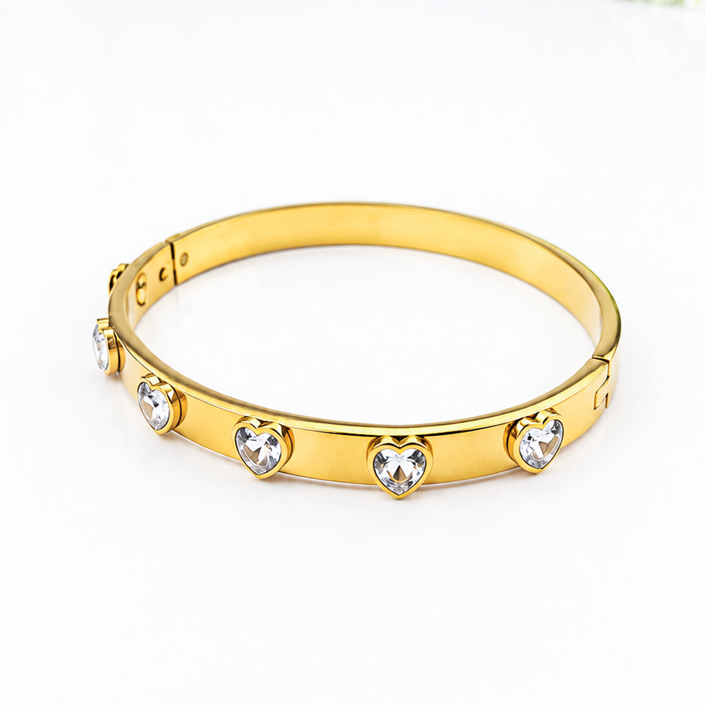 Gold-plated bangle bracelet featuring heart-shaped crystal embellishments