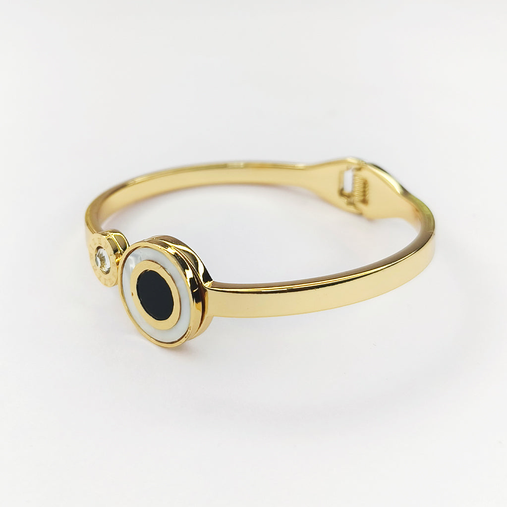 Gold-plated bangle bracelet with a black and white circular onyx stone inlay