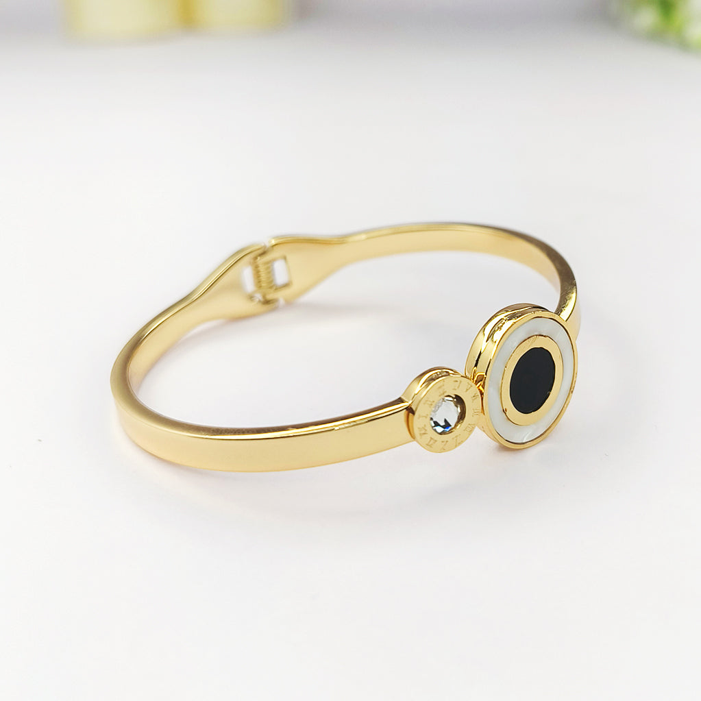 Elegant gold-plated bangle bracelet with a black onyx stone and a small crystal accent.