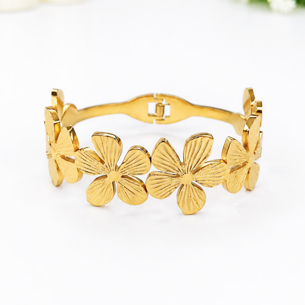 Elegant gold plated bangle bracelet featuring detailed flower motifs
