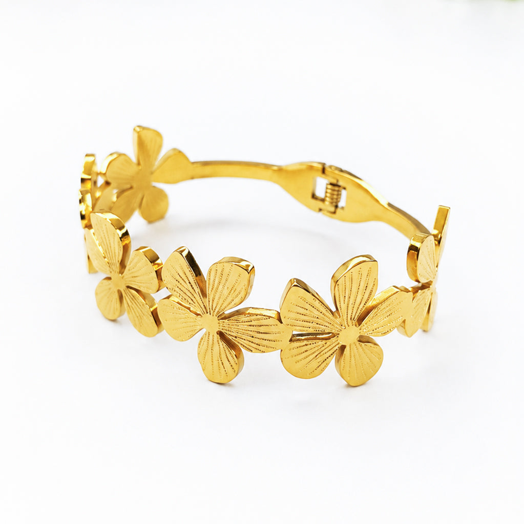 Gold-plated bangle bracelet featuring interlocking textured flower designs