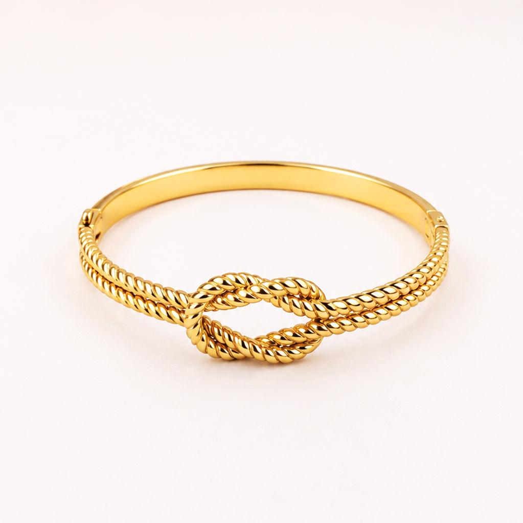 Gold-toned rope knot bangle bracelet on a white background