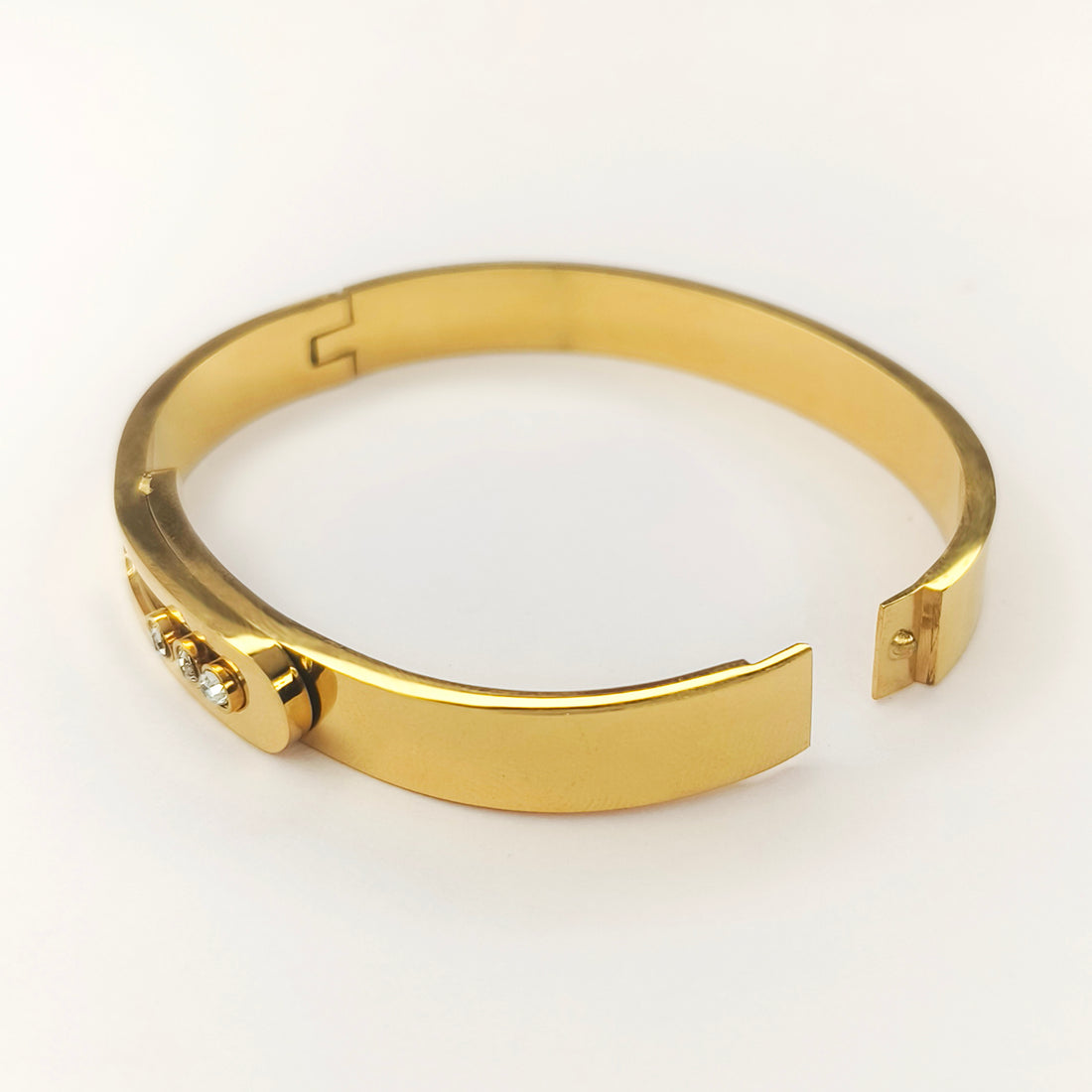 Gold-toned hinged bangle bracelet with three small inset crystals