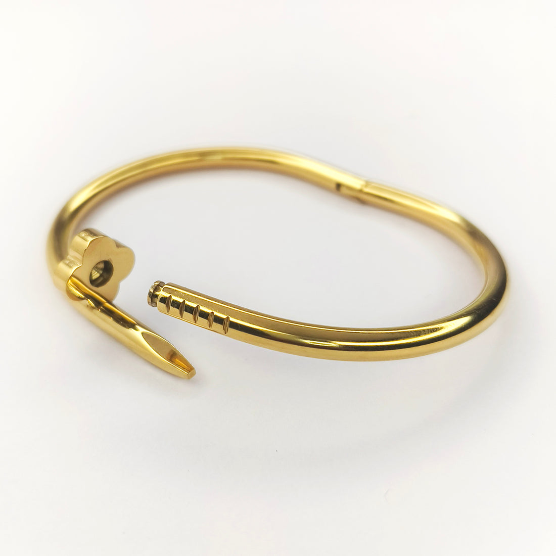 Elegant gold-plated bangle bracelet with a unique nail-shaped clasp design.