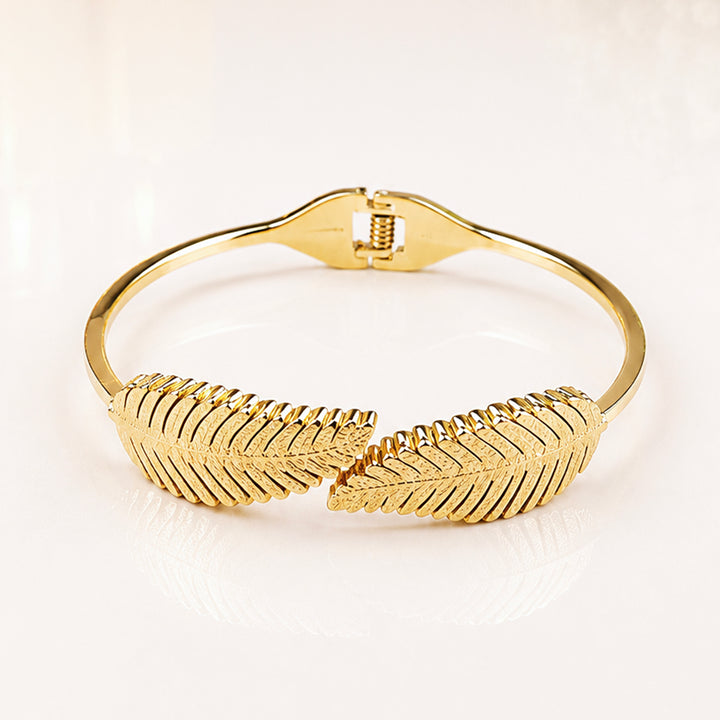 Elegant gold leaf design bangle bracelet with textured feather pattern.