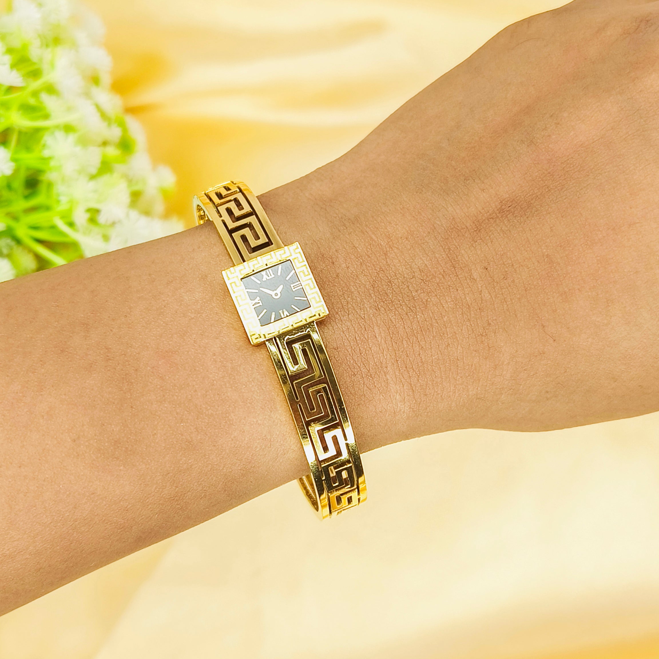 Gold Greek key pattern ladies' wristwatch on a woman's wrist