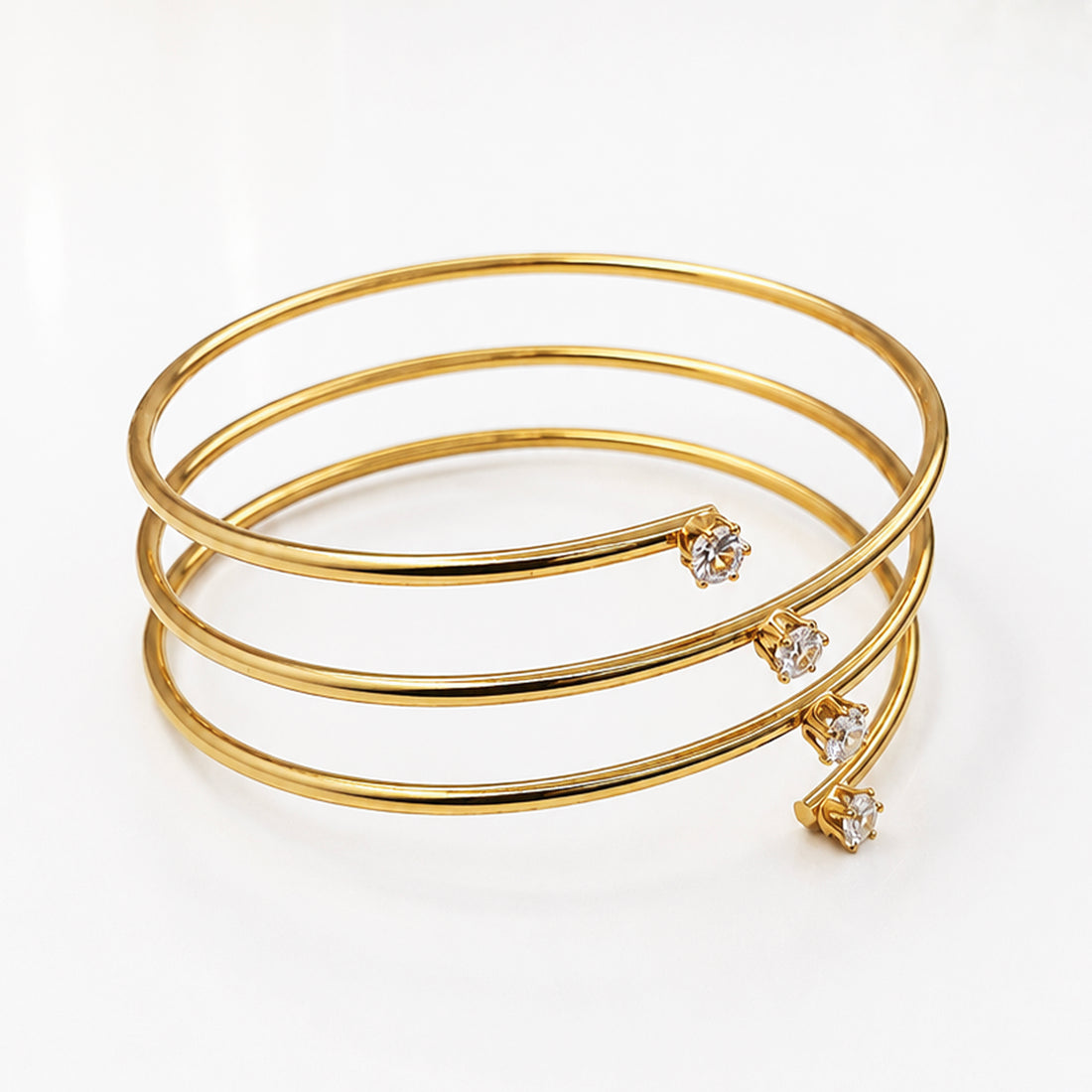 Elegant gold-plated spiral cuff bracelet featuring small sparkling crystals on the ends