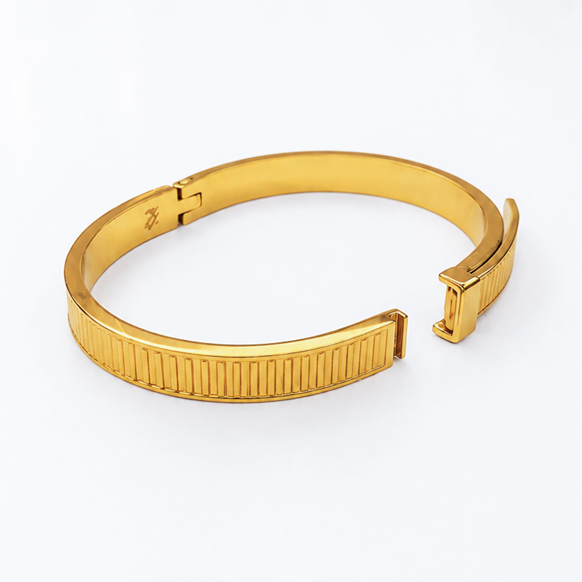 Elegant gold-plated open cuff bracelet with a textured ribbed design and sleek finish.
